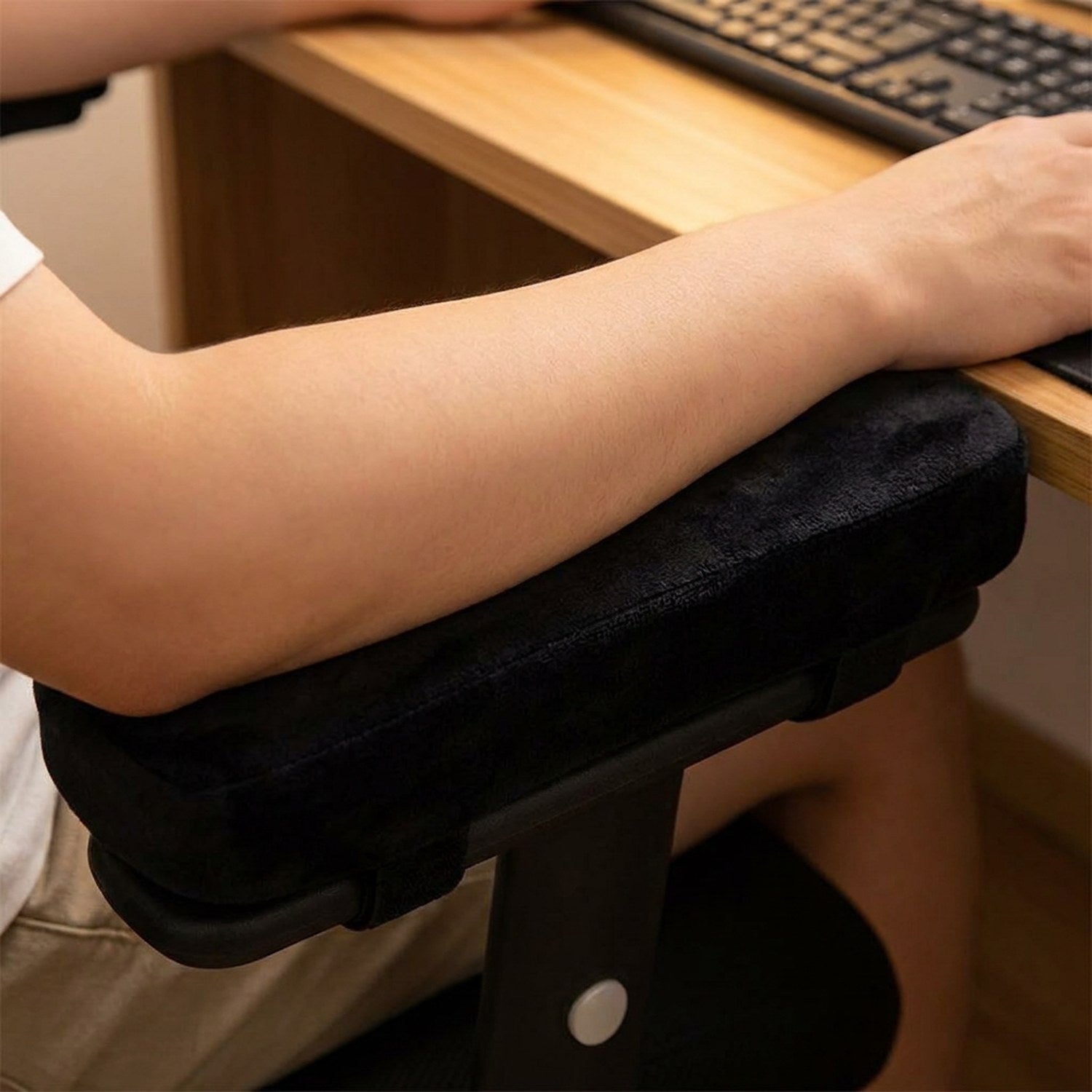 Avant-bras posé confortablement sur le coussin d'accoudoir noir près d'un clavier