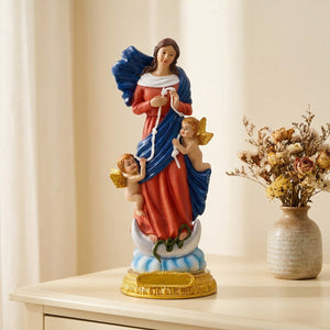 Figurine de la vierge Marie à la robe rouge sur une commode avec des fleurs séchées
