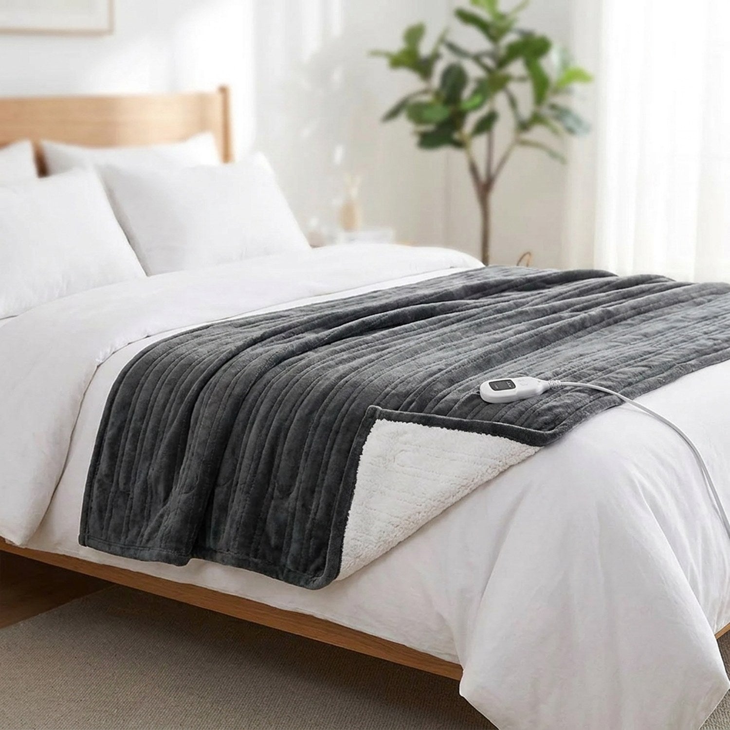 Couverture chauffante grise étalée au pied d un lit dans une chambre lumineuse