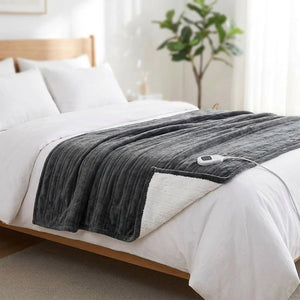 Couverture chauffante grise étalée au pied d un lit dans une chambre lumineuse