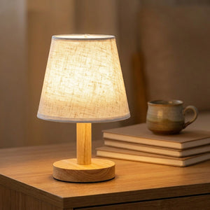 Lampe de chevet rétro allumée sur un bureau en bois avec tasse en céramique