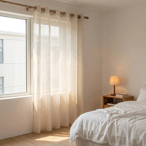 Rideau voilage effet lin dans une chambre chaleureuse avec lit et table de chevet