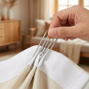 Main insérant un crochet à plis à quatre dents dans la bande de tête d'un rideau