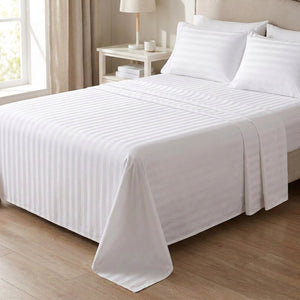 Drap plat rayé blanc satiné sur un lit près d'une fenêtre lumineuse