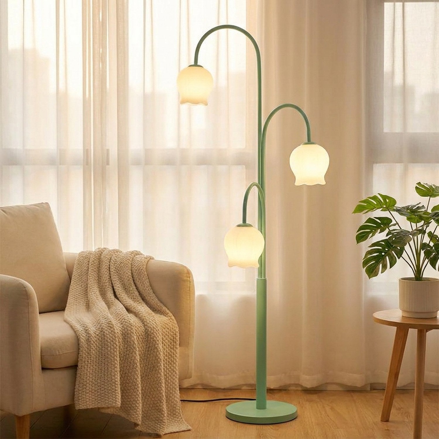 Lampadaire muguet à côté d'un fauteuil crème et d'une plante verte