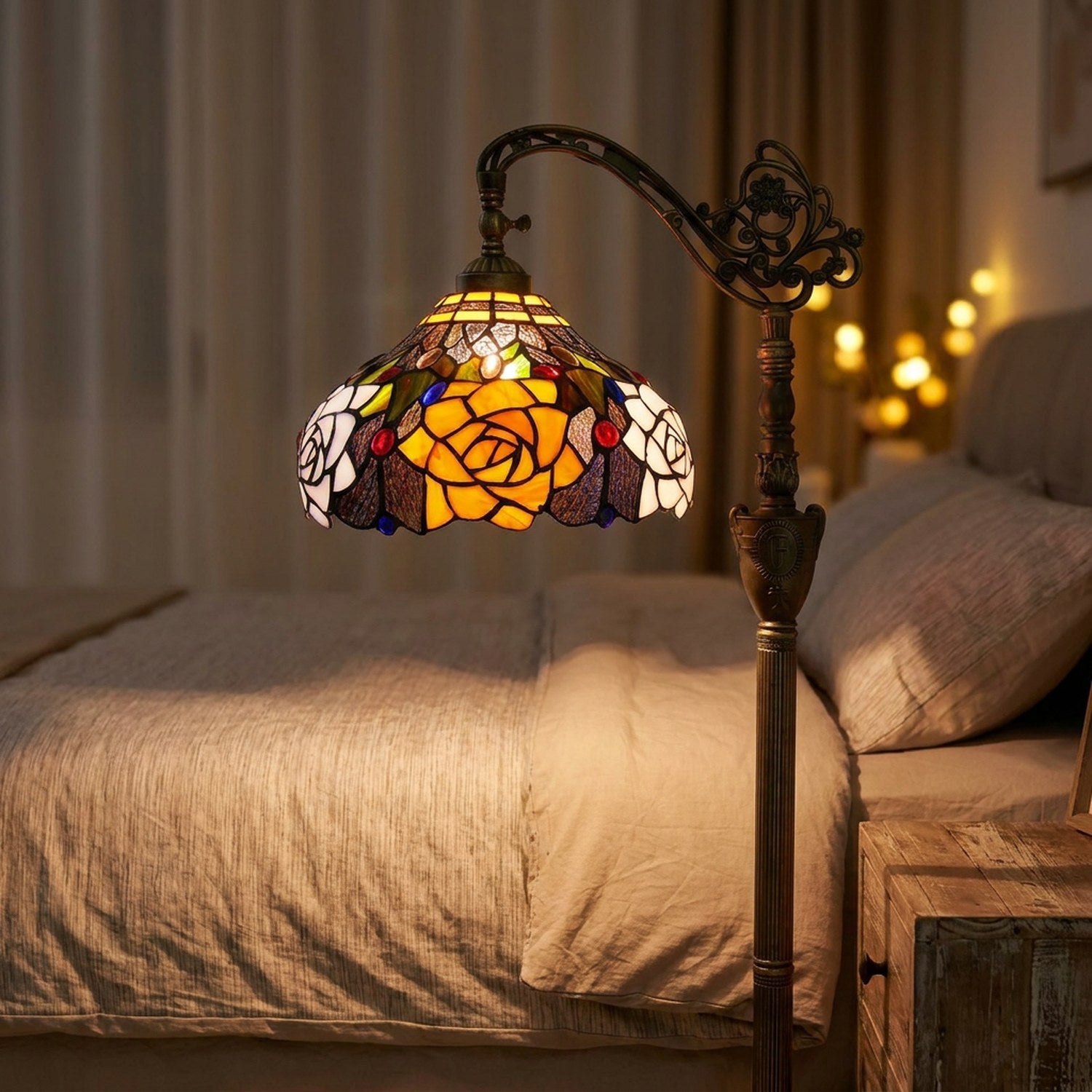 Lampadaire liseuse style Tiffany posé au chevet d'un lit dans une chambre chaleureuse le soir
