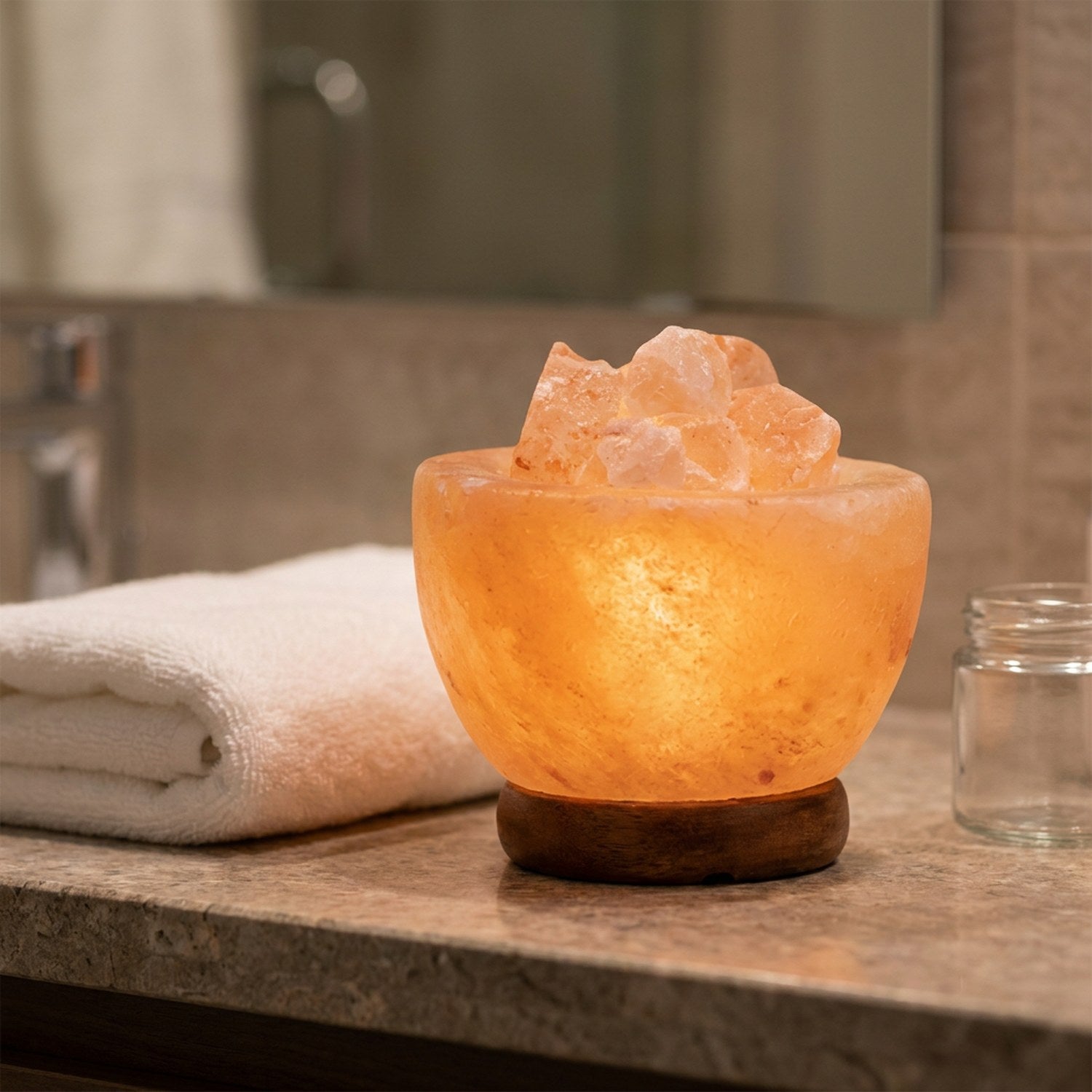 Lampe de sel de l'Himalaya sur un meuble de salle de bain avec une serviette