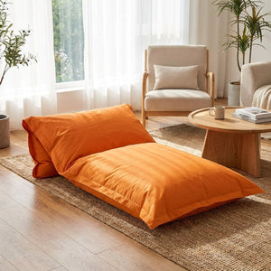 Pouf géant orange utilisé comme fauteuil dans un salon