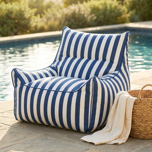 Housse de fauteuil pouf à rayures bleues et blanches installée au bord d'une piscine