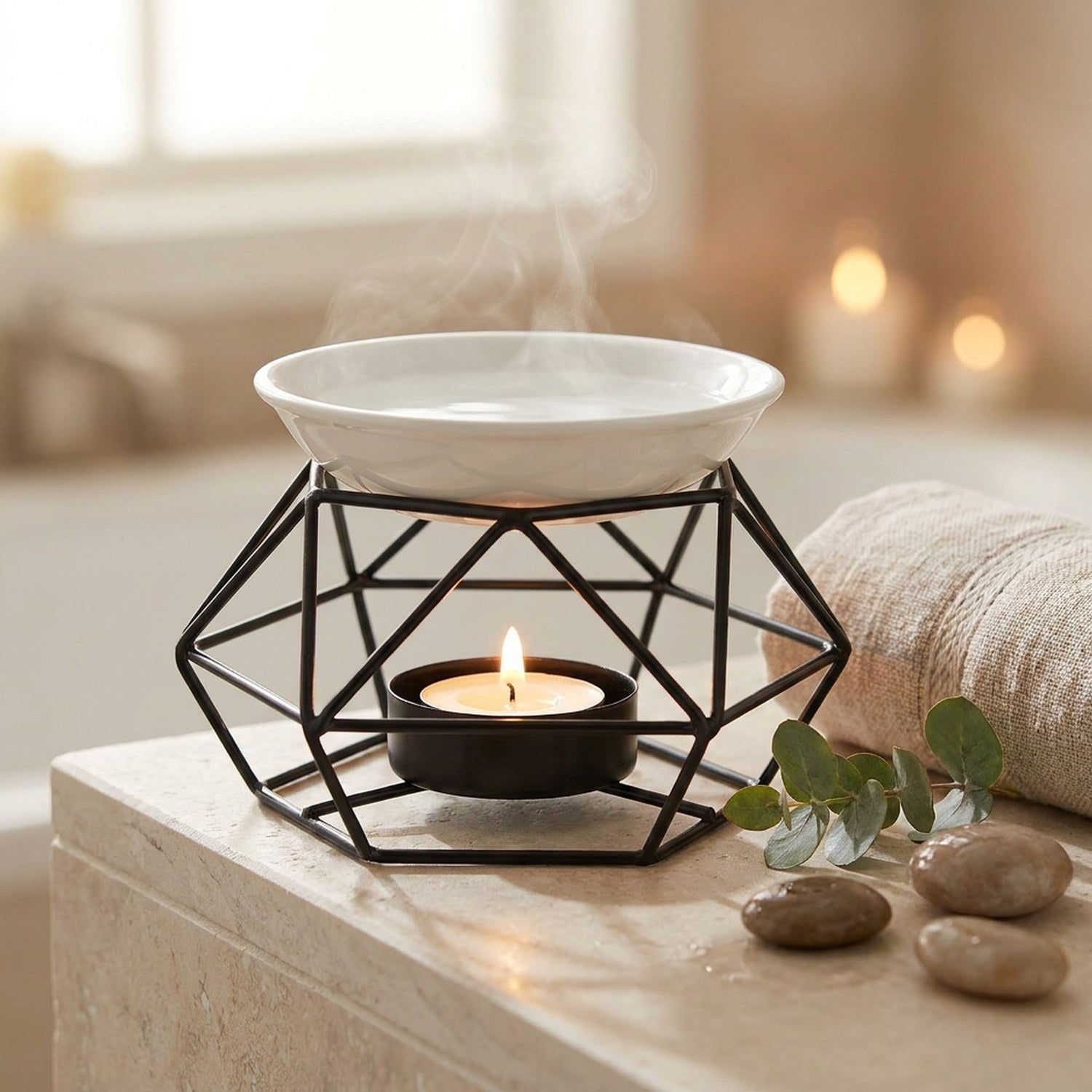 Brûle-parfum géométrique noir dans une salle de bain zen avec eucalyptus et galets