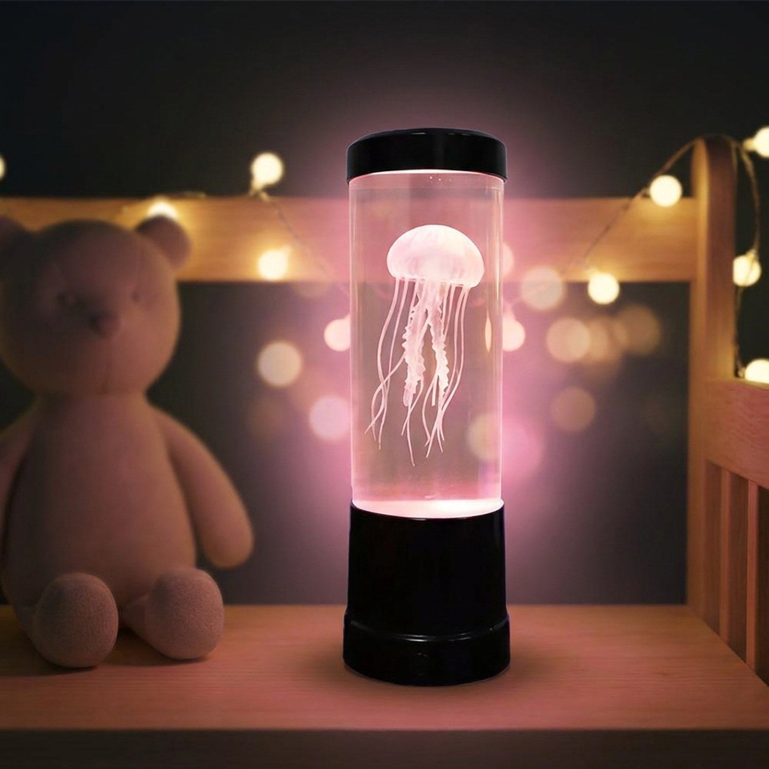 Lampe méduse USB allumée en rose dans une chambre d'enfant avec guirlande lumineuse