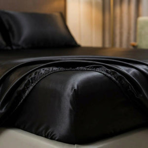Gros plan sur la bande élastique et le tissu satin brillant du drap housse noir