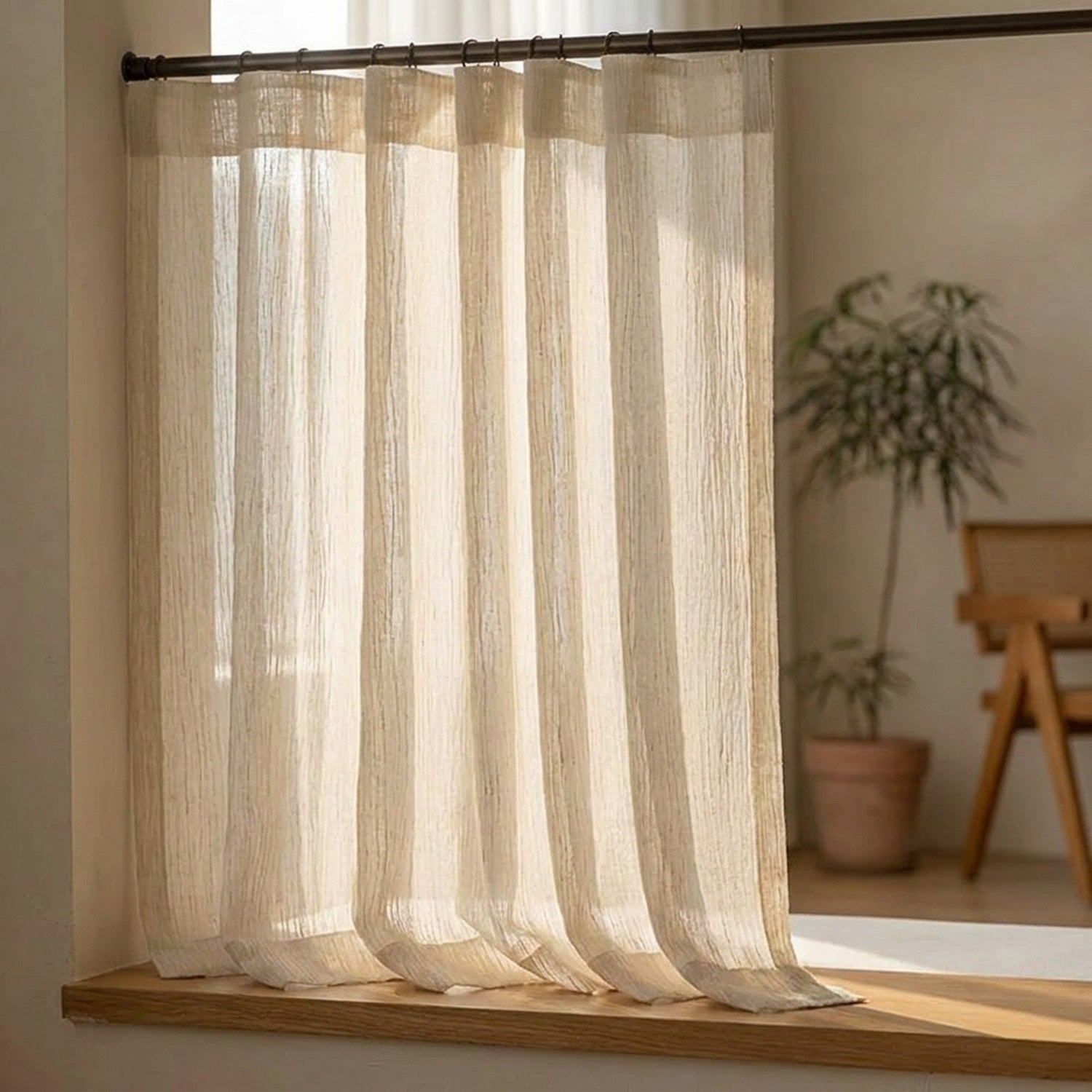Gros plan du voilage texturé beige au tombé fluide près d'une fenêtre