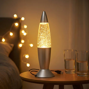 Lampe à lave USB argentée allumée en orange près de deux verres pour une soirée entre amis