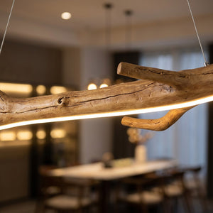 Lustre en résine noire suspendu dans un salon de thé cosy avec fauteuils et lumière dorée