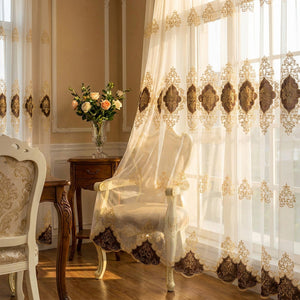 Rideau voilage brodé doré près d'une chaise classique et d'un bouquet de fleurs