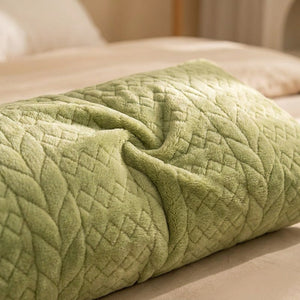 Gros plan sur la texture peluche et le motif losange matelassé de la housse de traversin