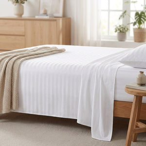 Drap plat rayé blanc sur un lit dans une chambre scandinave lumineuse