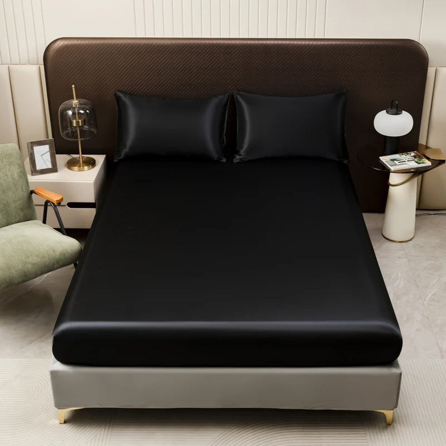Drap housse en satin noir installé sur un lit avec taies assorties