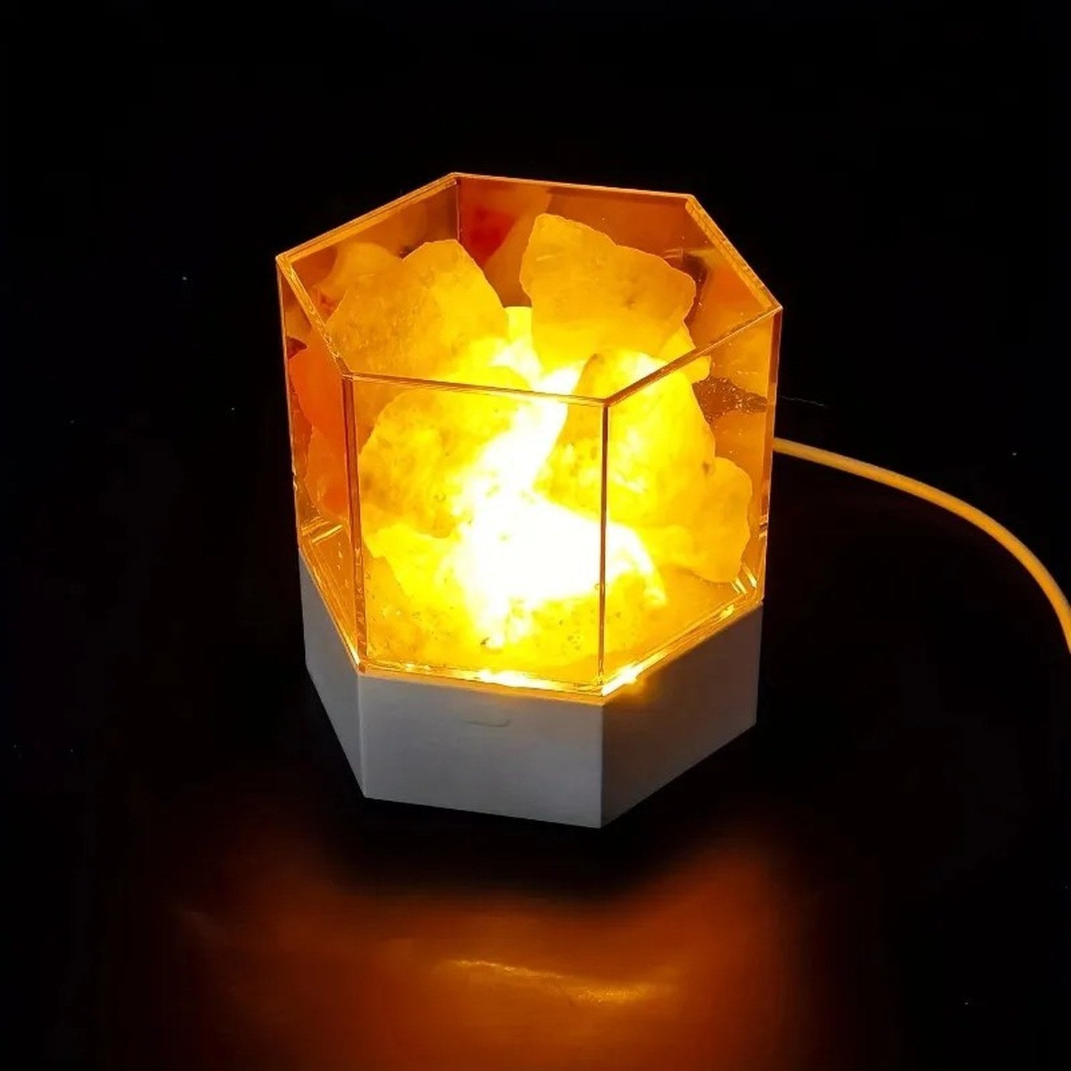 Lampe de sel hexagonale en cristal naturel allumée sur fond sombre