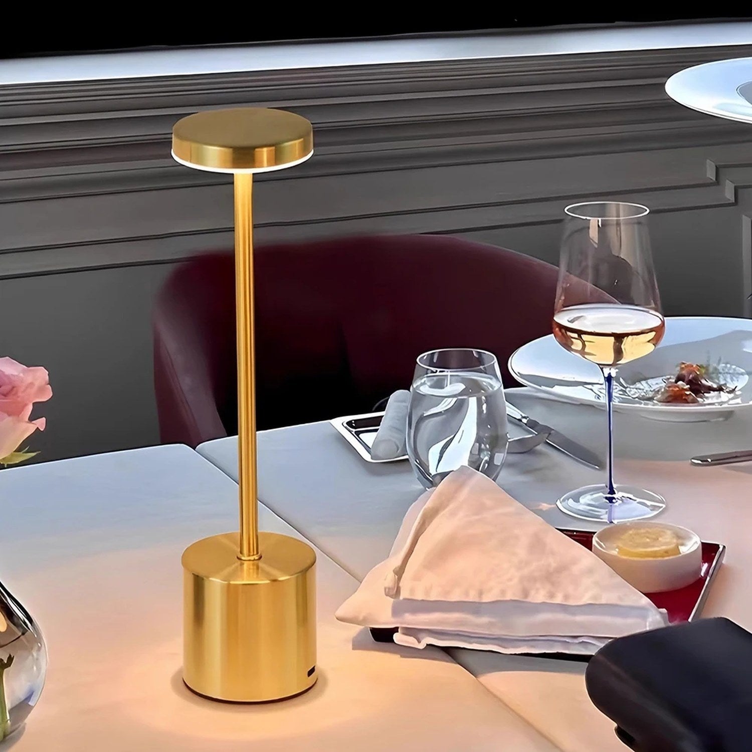 Lampe de table dorée allumée sur une table de restaurant dressée