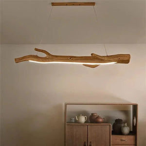 Lustre suspendu en résine forme branche allumé au dessus d'un meuble bas en bois