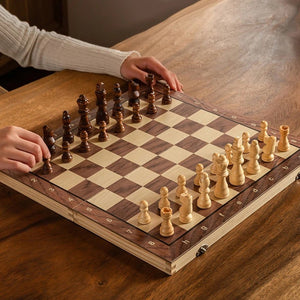 Partie d'échecs en cours sur l'échiquier en bois pliable entre deux personnes