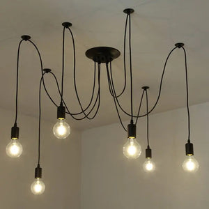 Lustre araignée noir installé au plafond avec ses ampoules à filament allumées