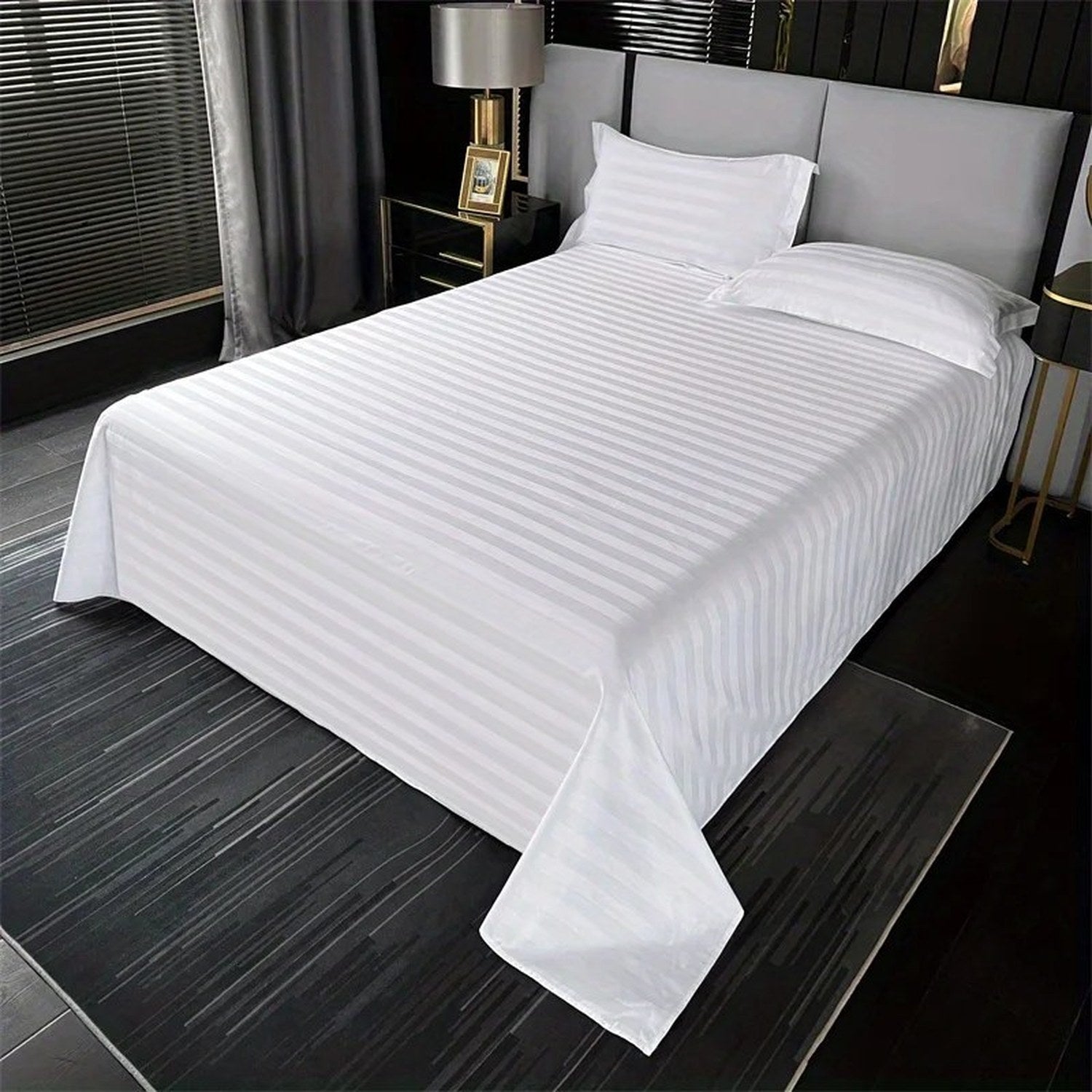 Drap plat rayé blanc satiné déployé sur un lit double