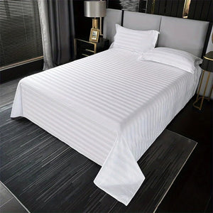 Drap plat rayé blanc satiné déployé sur un lit double