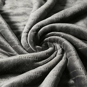 Gros plan sur la texture douce en flanelle grise de la couverture chauffante