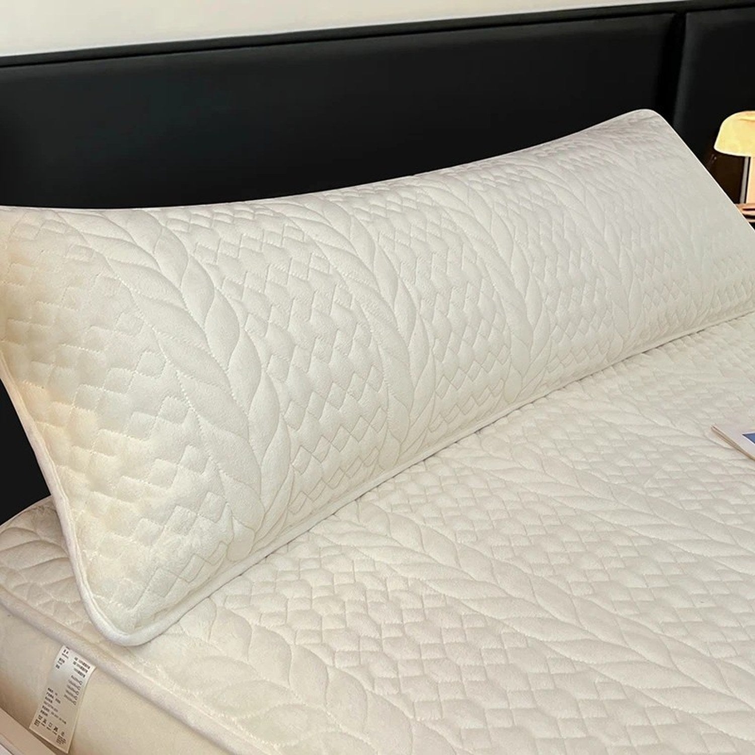 Housse de traversin en peluche matelassée blanc crème sur un lit