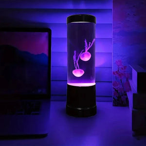 Lampe méduse allumée en violet posée sur un bureau le soir