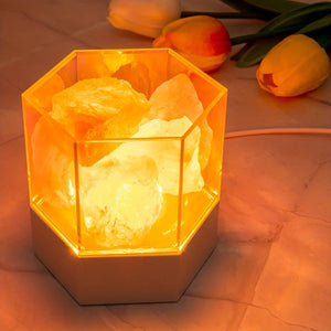 Lampe de sel hexagonale allumée sur une table avec des tulipes