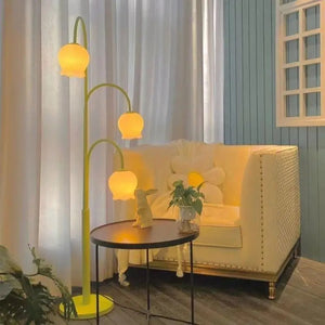 Lampadaire muguet allumé près d'un fauteuil dans un salon cosy