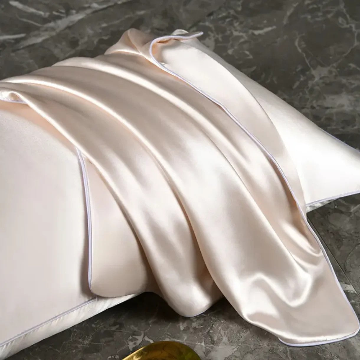 Gros plan sur le tissu satiné plissé d'une taie d'oreiller en soie beige