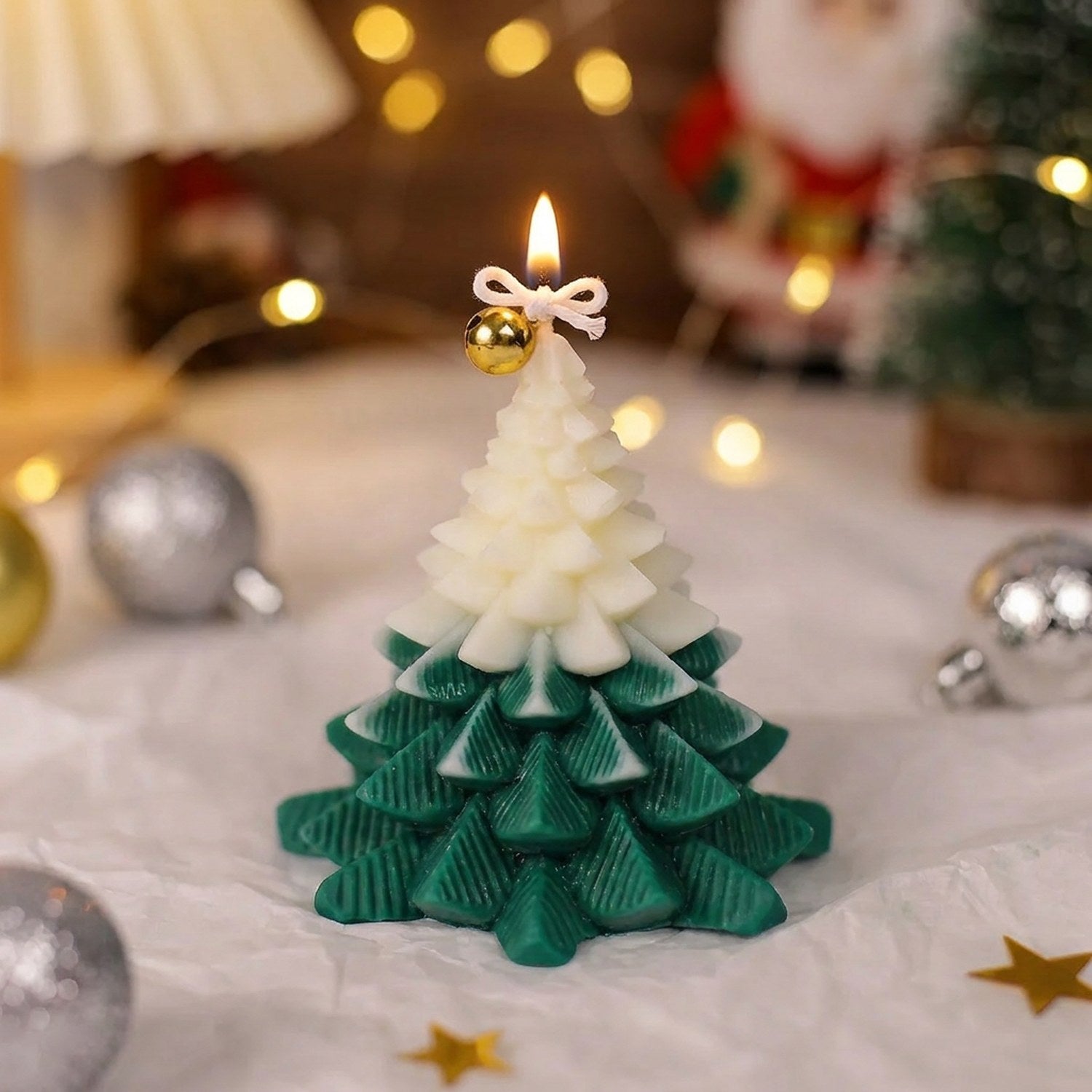 Bougie sapin de Noël enneigée verte et blanche allumée