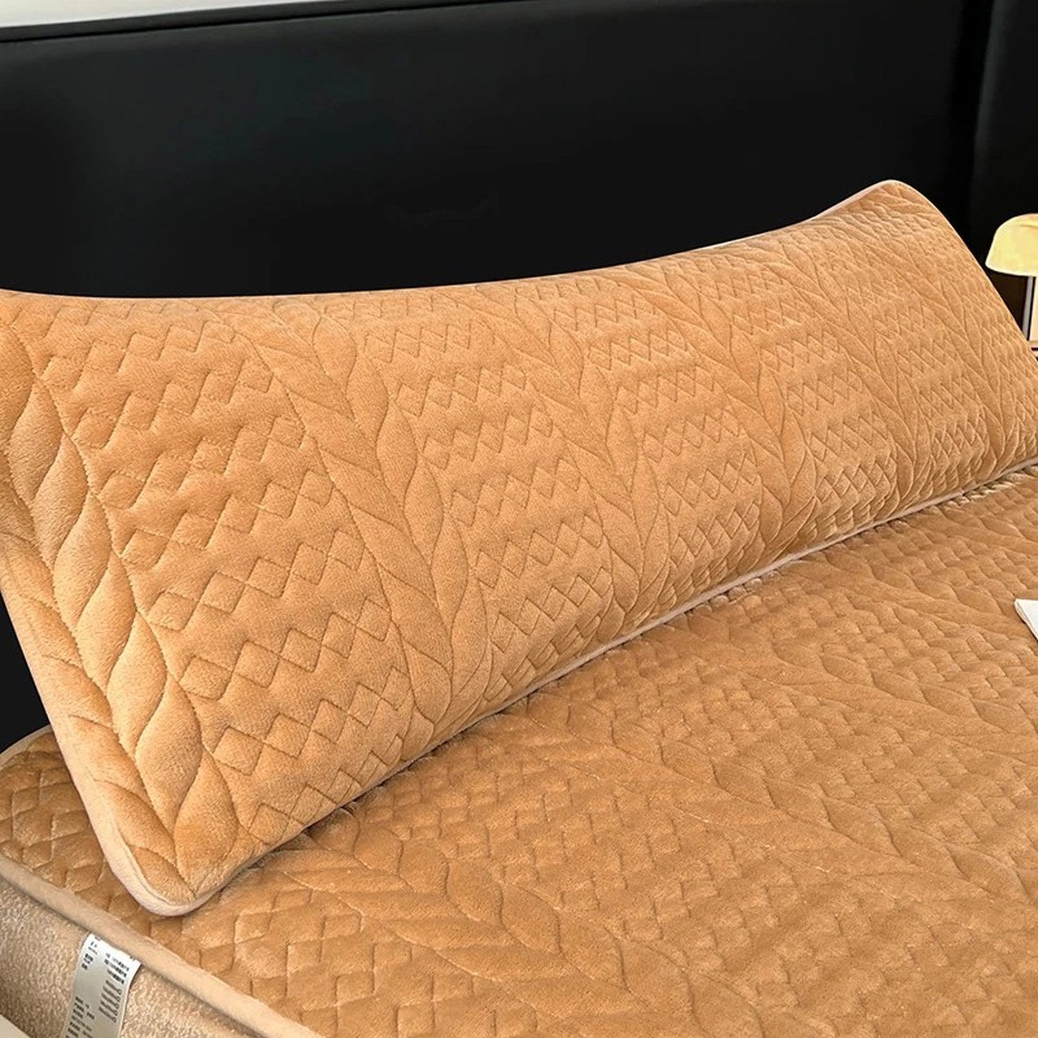 Housse de traversin en peluche matelassée caramel sur un lit