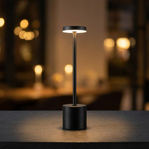 Lampe de table sans fil en métal noir mat allumée diffusant une lumière chaude