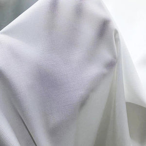 Gros plan sur le tissage mousseline blanc du voilage avec ses plis légers