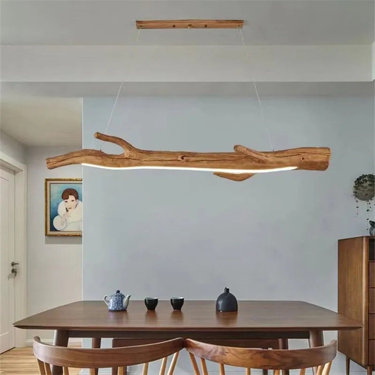 Lustre suspendu en résine forme branche au dessus d'une table en bois avec théière