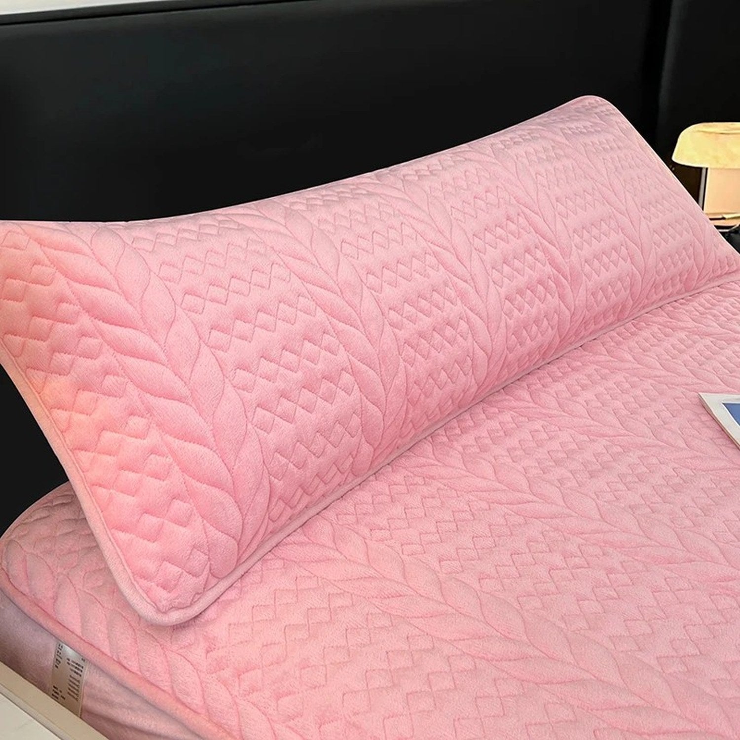 Housse de traversin en peluche matelassée rose sur un lit