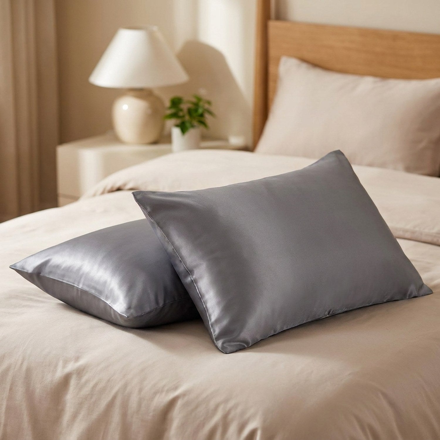 Deux taies d'oreiller en satin gris sur un lit