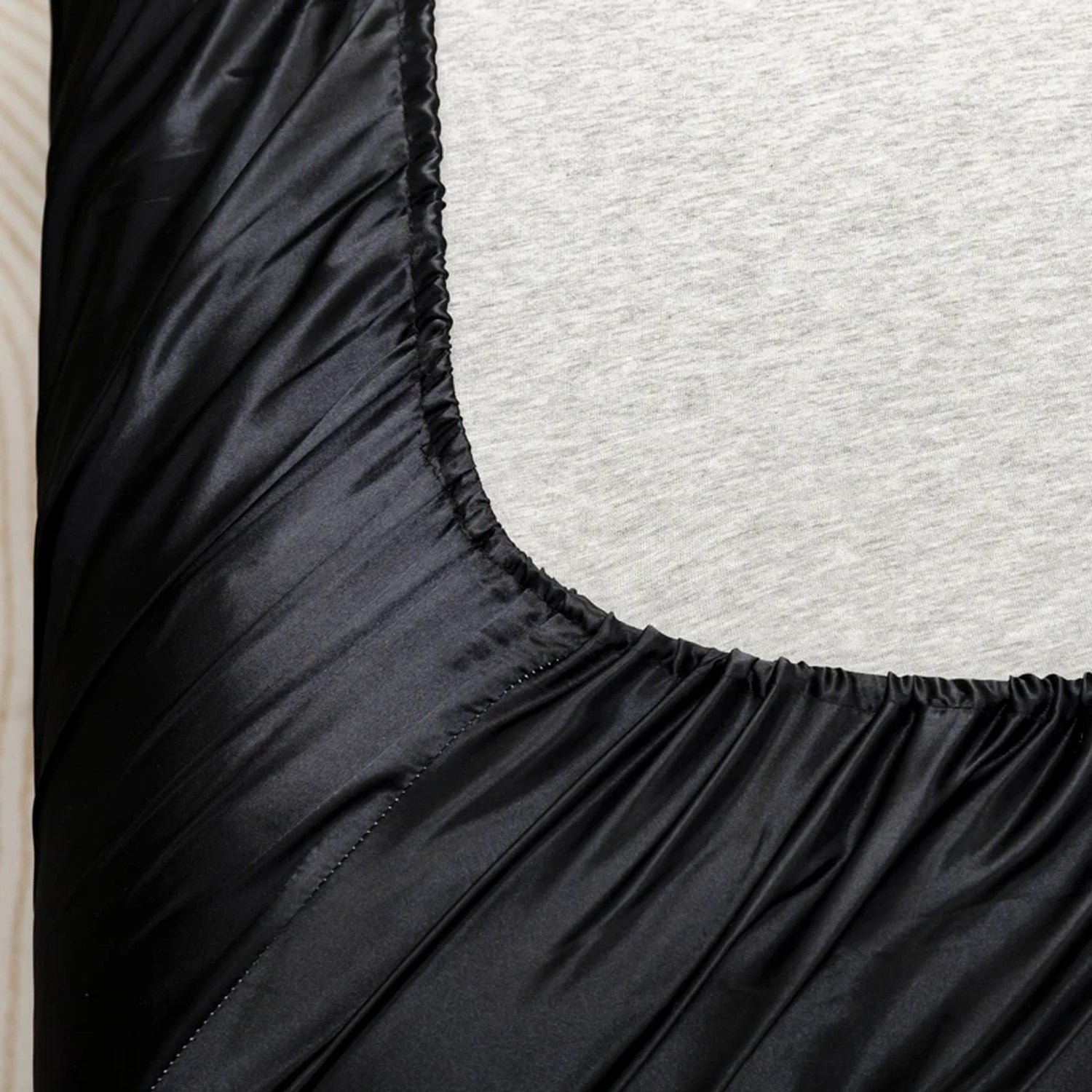 Détail de la bande élastique cousue du drap housse satin sur le matelas