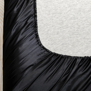Détail de la bande élastique cousue du drap housse satin sur le matelas