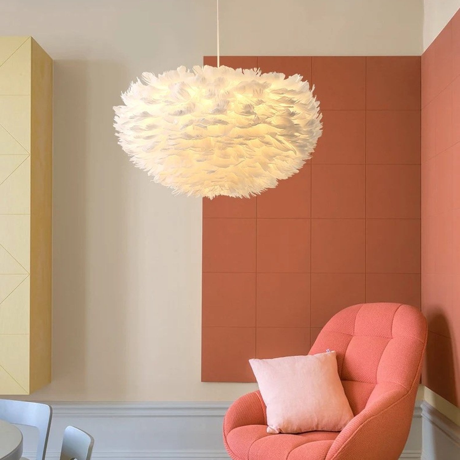 Suspension boule en plumes blanches allumée dans un salon moderne