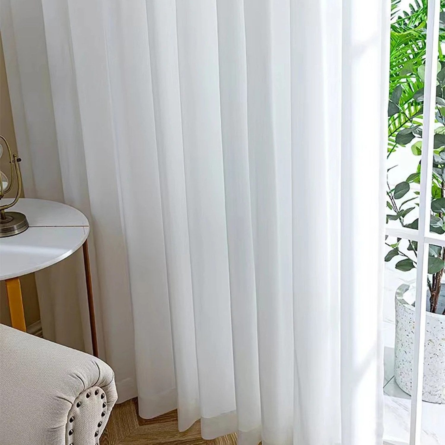 Voilage blanc du sol au plafond dans un salon moderne avec fauteuil chiné et tapis à damiers