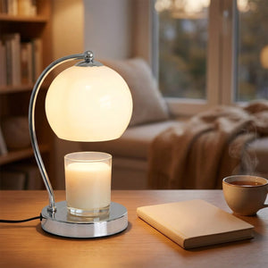 Lampe chauffe-bougie blanche sur un bureau avec carnet et tasse de thé