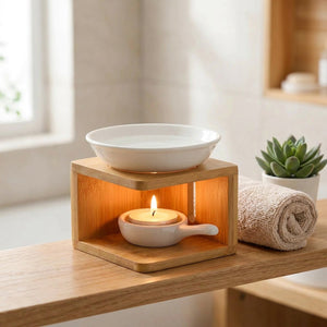 Brûle-parfum en céramique et bambou allumé sur une étagère de salle de bain avec serviette et plante