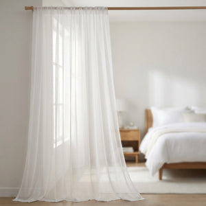 Voilage blanc transparent en tulle devant une fenêtre de chambre avec lumière du matin